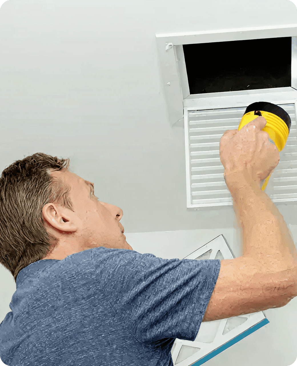 Person examining wall vent closely