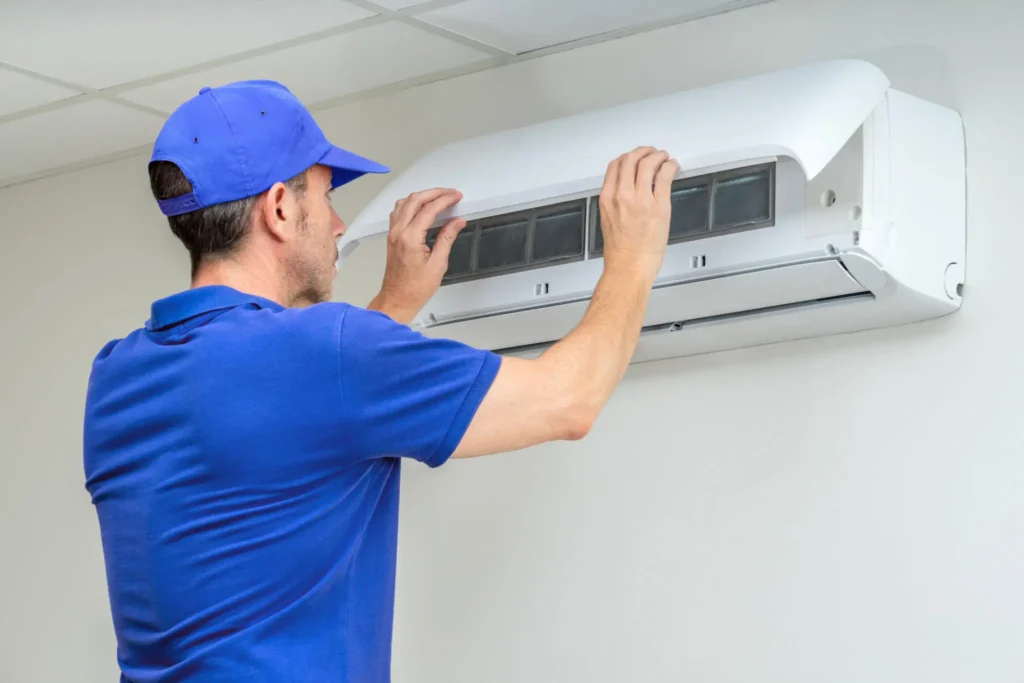 Technician repairing a wall-mounted air conditioner.