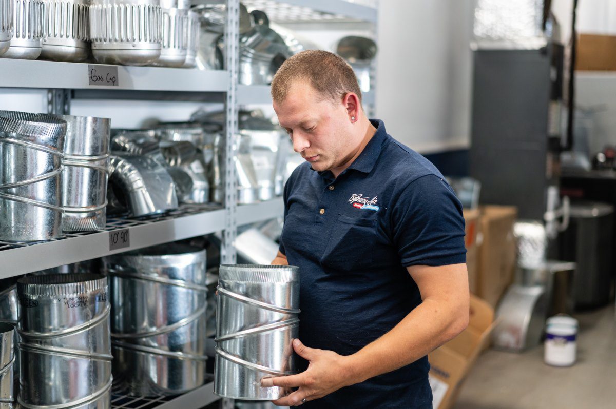 HVAC technician organizing ductwork supplies for professional cooling services in Edgewater MD.