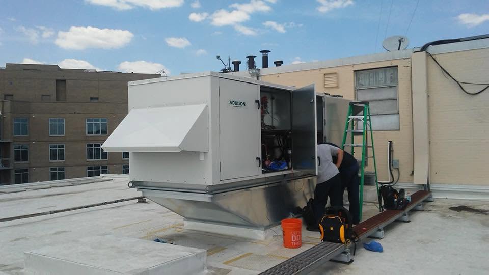 HVAC contractor in Arden on the Severn, MD servicing rooftop air conditioning unit on commercial building