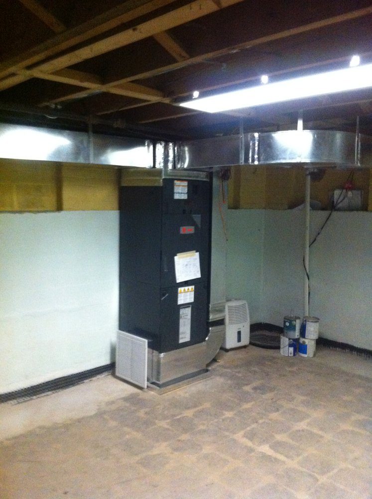 Newly installed indoor furnace system and metal ductwork in an unfinished basement in Annapolis, MD.