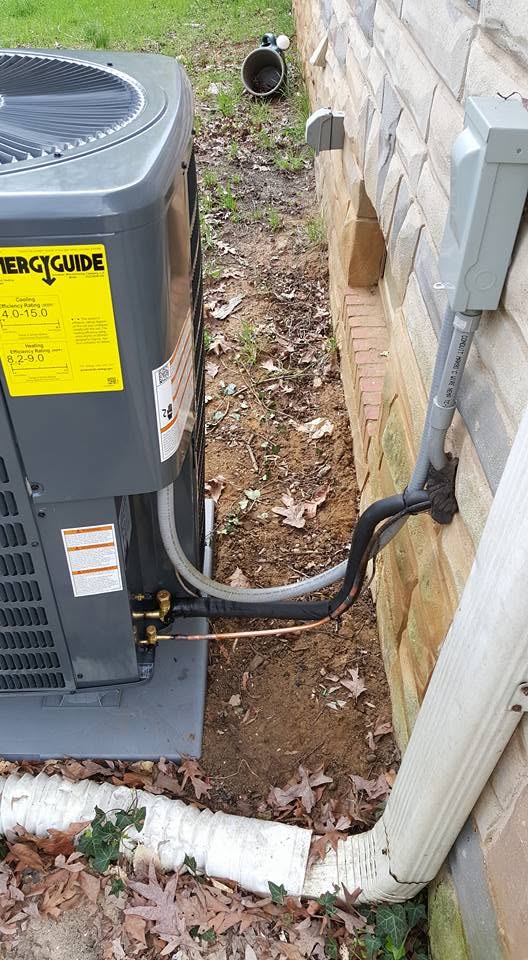 Outdoor heat pump unit with fresh refrigerant lines and electrical disconnect box in Annapolis, MD.