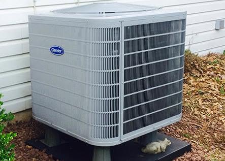 Carrier outdoor heat pump condenser unit set on a pad outside a residence in Annapolis, MD.