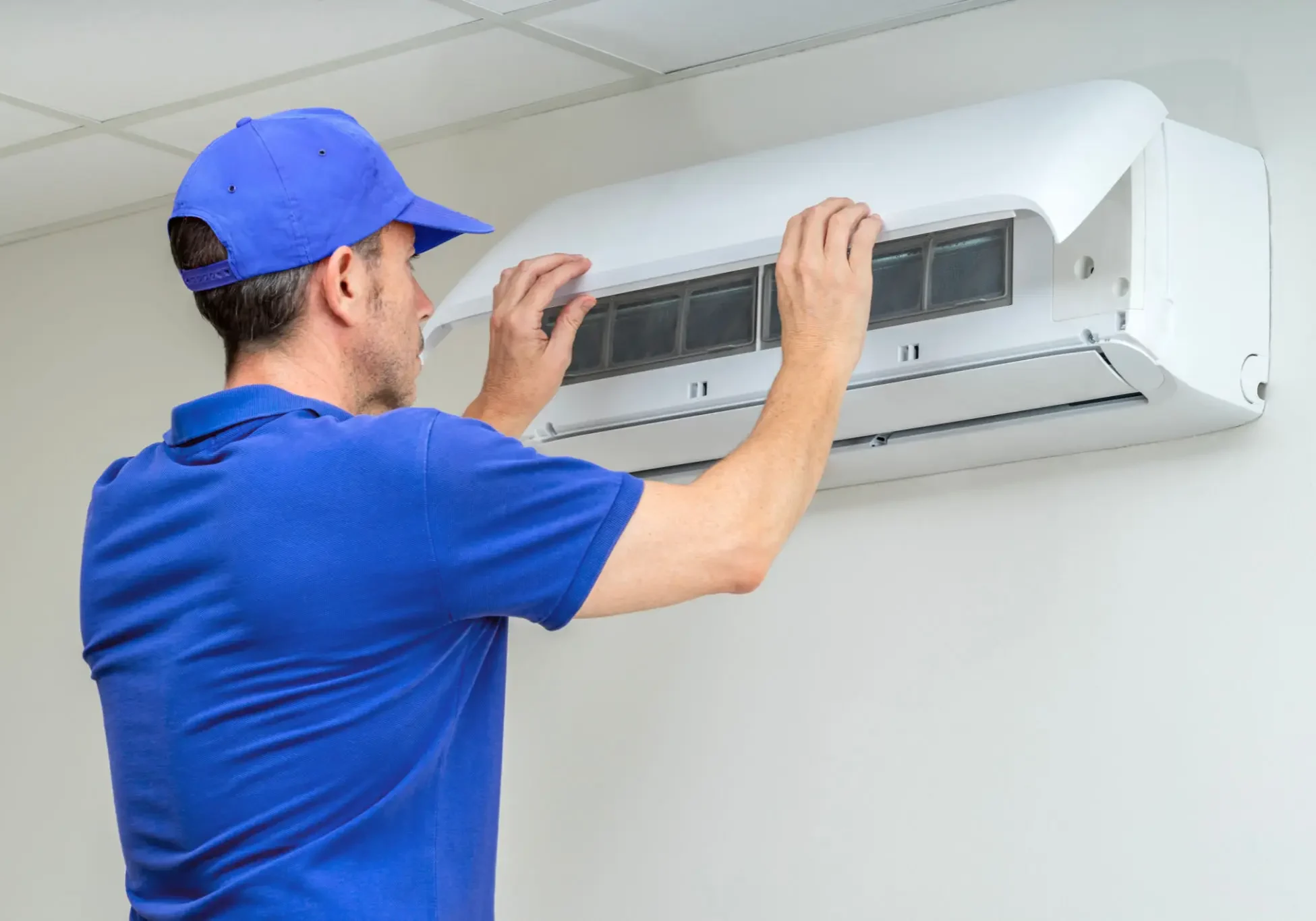 Technician repairing a wall-mounted air conditioner.